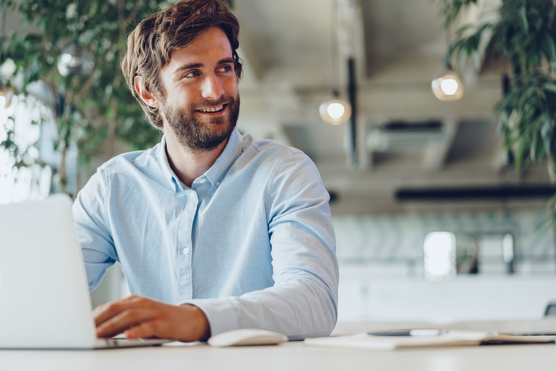 Businessman in shirt working on his laptop in an office. Open space office