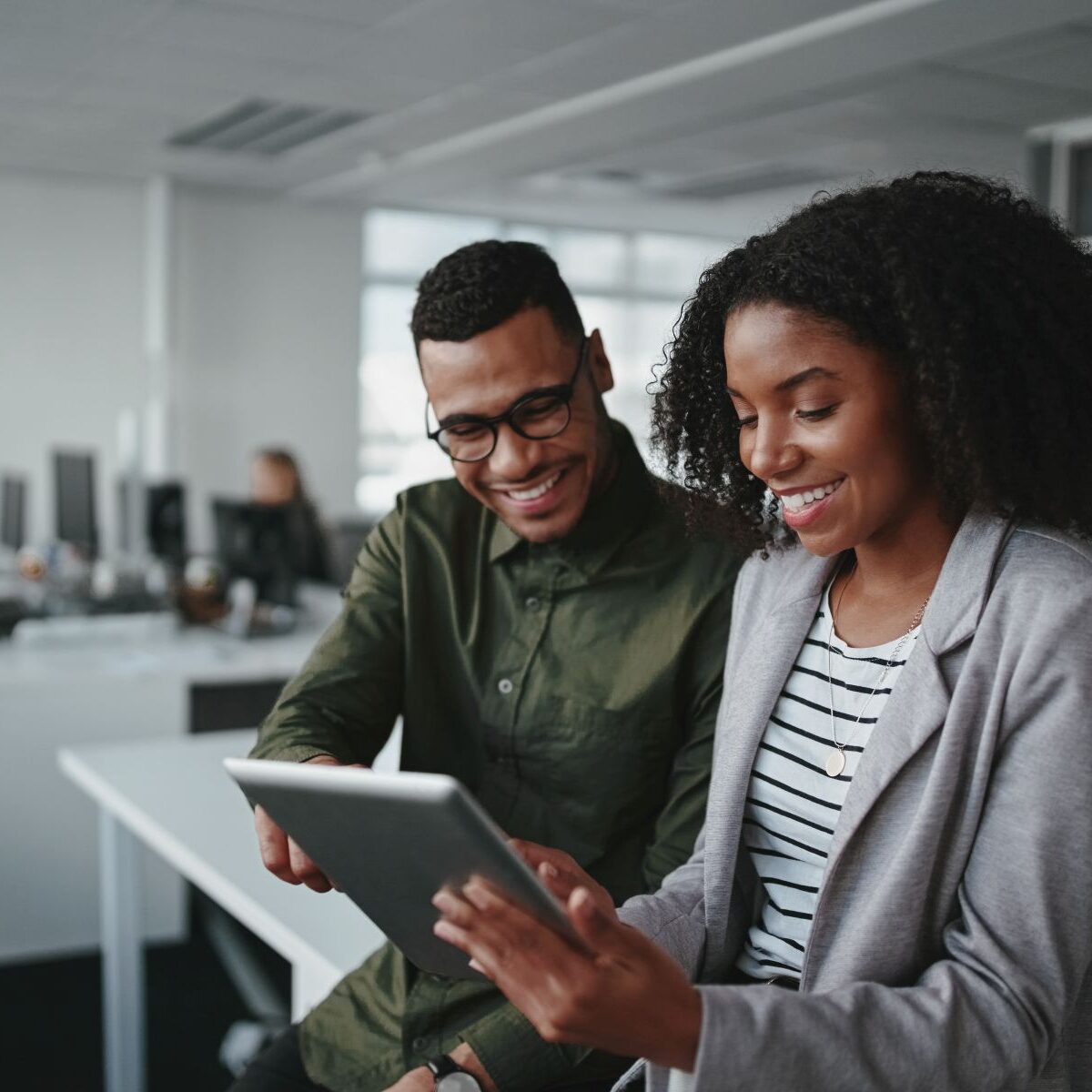 Professional young businesspeople using tablet computer smiling in office