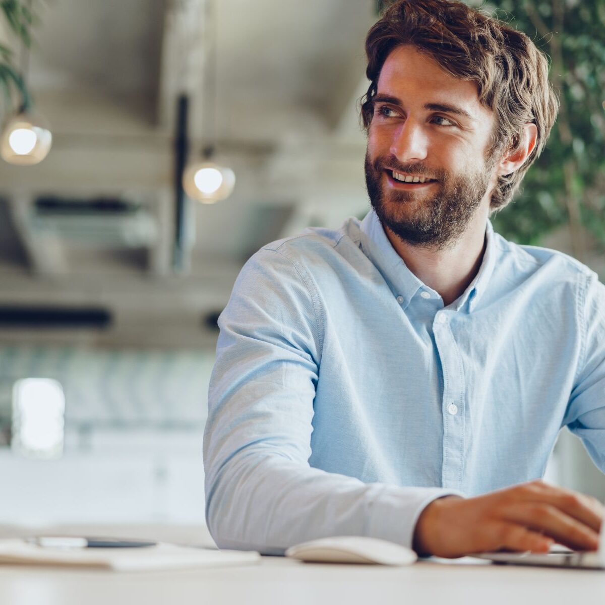 Businessman in shirt working on his laptop in an office Businessman in shirt working on his laptop in an office. Open space office