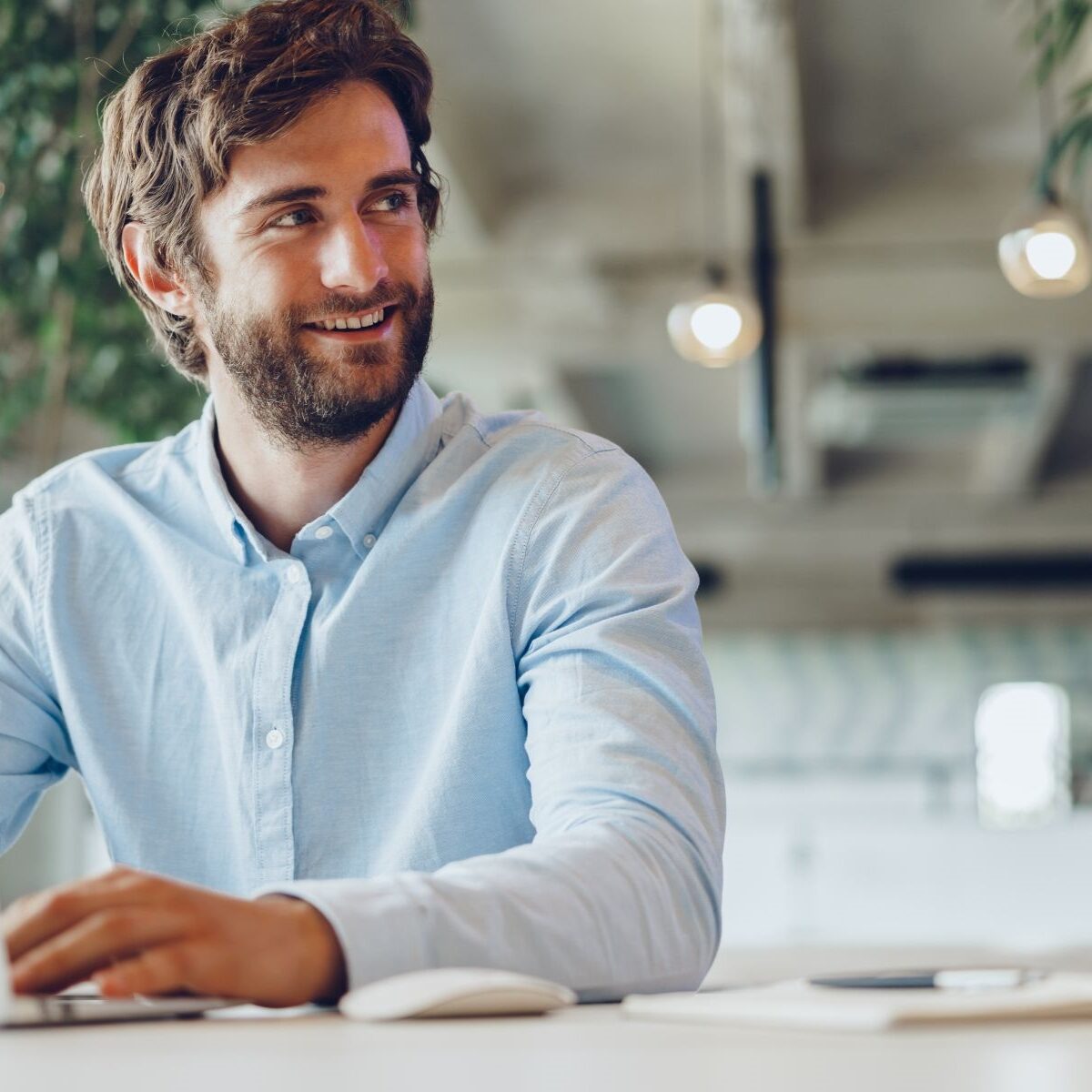 Businessman in shirt working on his laptop in an office. Open space office